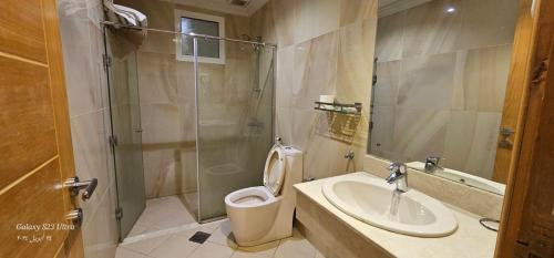 y baño con aseo, lavabo y ducha. en رام جده للشقق الفندقيه Ram Jeddah, en Yeda