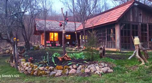 a log cabin with a red roof and a garden at Hidden Garden Kide (Chidea) in Cluj-Napoca