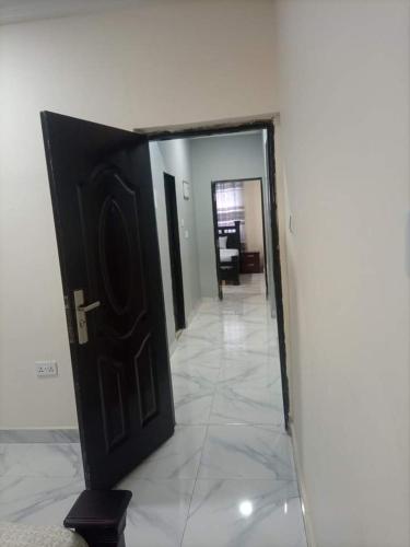 una puerta negra en una habitación con pasillo en Ana Rooms, en Tema