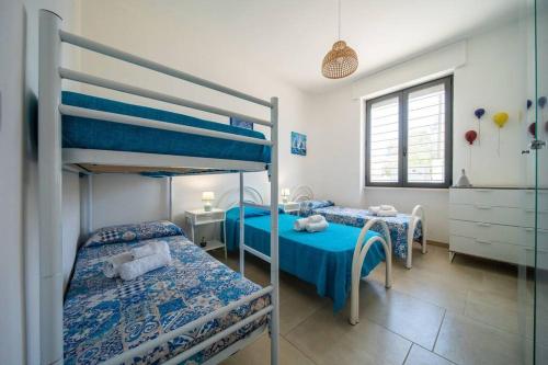 1 Schlafzimmer mit 2 Etagenbetten und einem Badezimmer in der Unterkunft A un passo dal Mare - Villa Corallo Torre Borraco in Manduria
