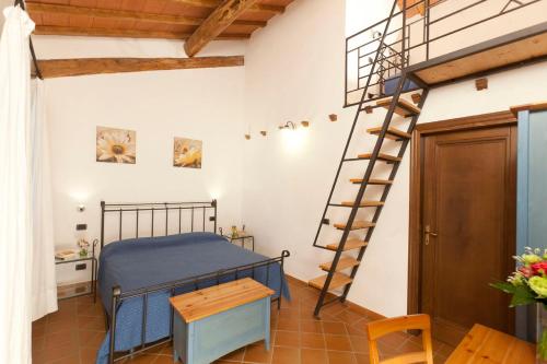 a bedroom with a bed and a spiral staircase at Agriturismo Le Spighe in San Donato