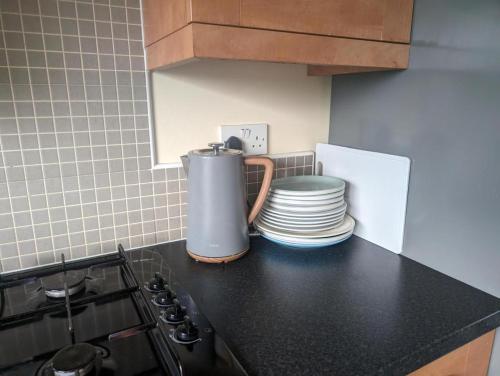 a kitchen counter with plates and a blender on it at Budget rooms in Dudley in Tipton