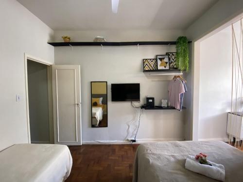 um quarto com uma cama e uma televisão na parede em Sunset Rio no Rio de Janeiro
