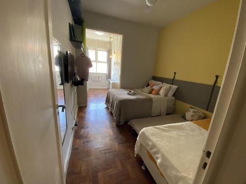 um quarto de hotel com duas camas e uma janela em Sunset Rio no Rio de Janeiro