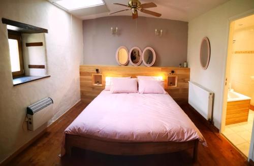 a bedroom with a bed and three mirrors on the wall at L'Olive in Saint-Bazile