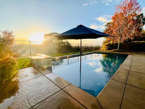 a swimming pool with an umbrella in a yard at Sunrise View in Rocklin