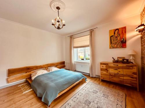 a bedroom with a bed and a dresser and a window at Sophisticated art deco near sea, centre and parks in Ventspils