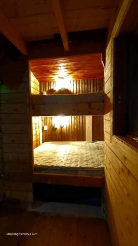 a small room with a bed in a wooden cabin at Hidden Garden Kide (Chidea) in Cluj-Napoca