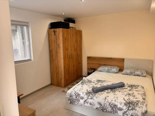 1 dormitorio con 1 cama y armario de madera en Nice house near city center of Ruse, en Ruse