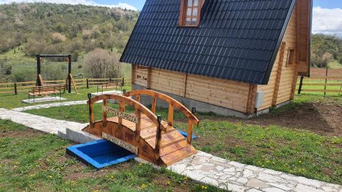 a wooden bench sitting in front of a building at ETNO SELO VEZIROV RANČ in Sjenica