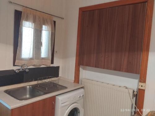 uma cozinha com um lavatório e uma máquina de lavar roupa em Erini Room em Kissamos