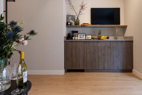 a living room with a tv and a bottle of wine at Monciak Elegance - Plaża in Sopot