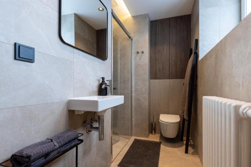a bathroom with a sink and a shower and a toilet at Monciak Elegance - Plaża in Sopot