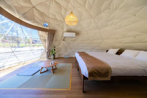 sypialnia w namiocie z łóżkiem i stołem w obiekcie NAGOMI CAMP - Vacation STAY 48649v w mieście Nasushiobara