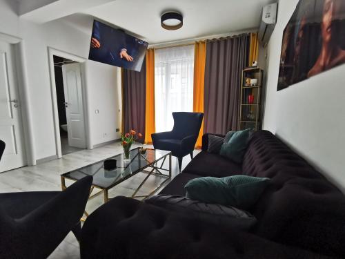 een woonkamer met een bank en een tafel bij Residence TRL - Otopeni in Otopeni