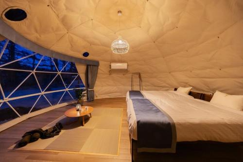 a bedroom in a dome tent with a bed and a table at NAGOMI CAMP - Vacation STAY 48650v in Nasushiobara