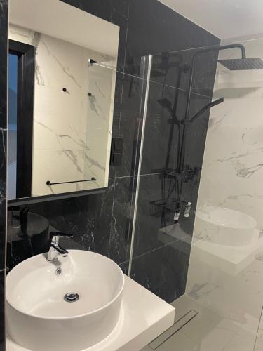 a bathroom with a sink and a glass shower at Apartament Morski Spokój Solny Resort in Kołobrzeg