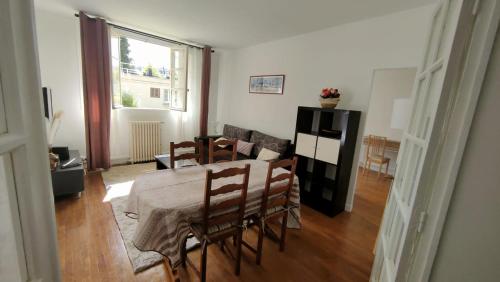 sala de estar con mesa de comedor y sillas en Bel appartement, Bry- sur- Marne, en Bry-sur-Marne