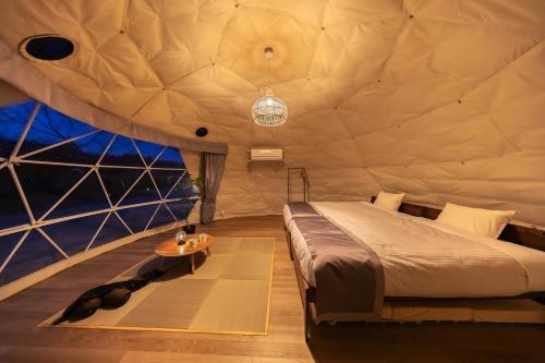 a bedroom in a dome tent with a bed and a table at NAGOMI CAMP - Vacation STAY 48654v in Nasushiobara