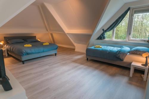 Schlafzimmer im Dachgeschoss mit 2 Betten und einem Fenster in der Unterkunft The Poplar Place in Zeewolde