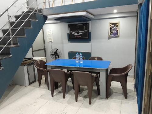 a blue table and chairs in a room with a staircase at M k home stay in Ujjain