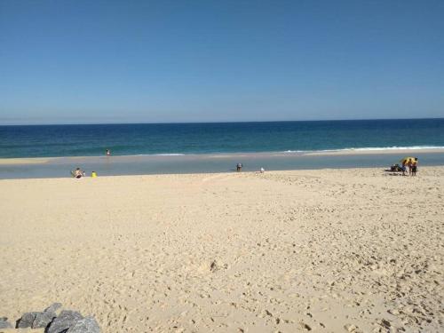 a group of people on a beach with the ocean at Espaço familiar in Maricá