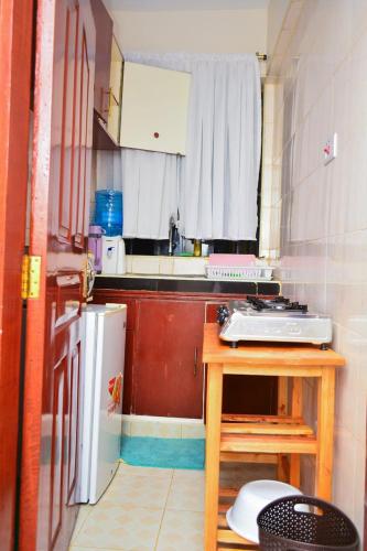 una piccola cucina con tavolo e frigorifero di The Nifty Apartment a Kisumu