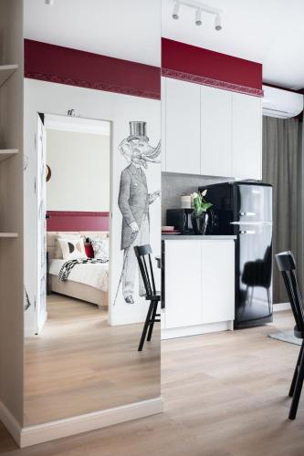 a living room with a refrigerator and a table and chairs at Apartament Bajka in Grudziądz