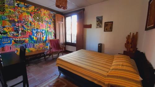 ein Schlafzimmer mit einem Bett und einem Wandgemälde in der Unterkunft Hotel Anáhuac in Juayúa