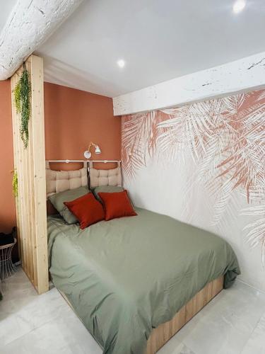 - une chambre avec un lit et un mur orné d'une peinture dans l'établissement Le Charvet, Studio cosy en plein cœur de Hyères, à Hyères