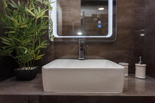 a white sink in a bathroom with a mirror at Apartament Paris in Durleşti