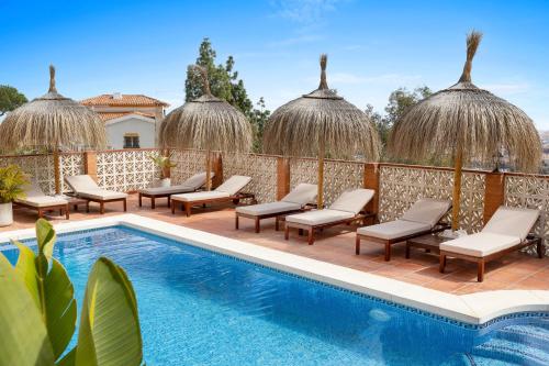 un resort con piscina e sedie a sdraio di Bed & Breakfast Villa Botánica a Málaga