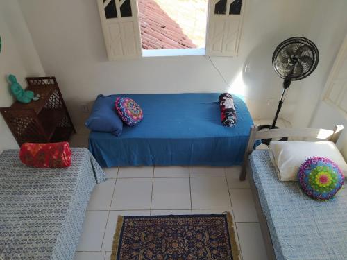 uma sala de estar com um sofá azul e uma ventoinha em Hostel do Capao em Palmeiras