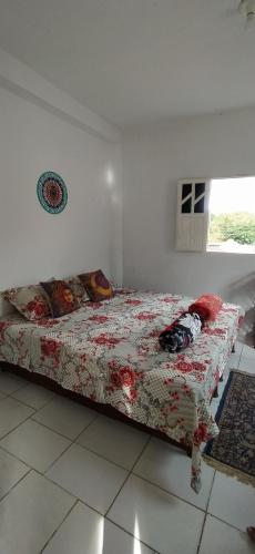 a bedroom with a bed with a flowered blanket at Hostel do Capao in Palmeiras