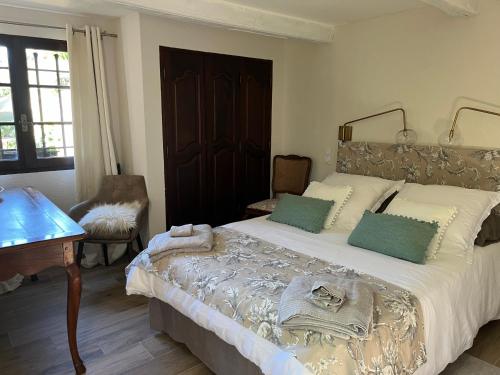 - une chambre avec un grand lit, une table et des chaises dans l'établissement PROCHE GRASSE - LE MAS de la MADONETTE, à Spéracèdes