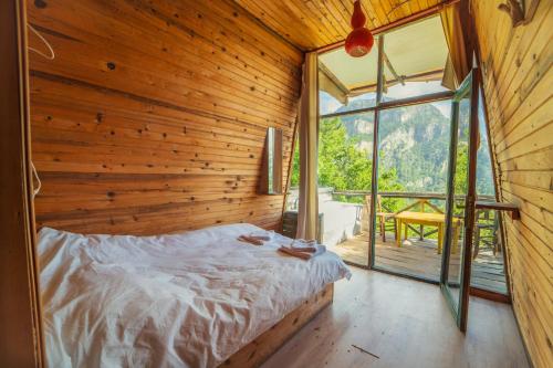 sypialnia z łóżkiem w drewnianej ścianie w obiekcie Shiva Camp w mieście Faralya