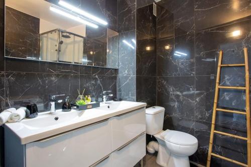 une salle de bain avec un lavabo, des toilettes et un miroir dans l'établissement 4 pièces 8 personnes proche aéroport,tramway, à Nice