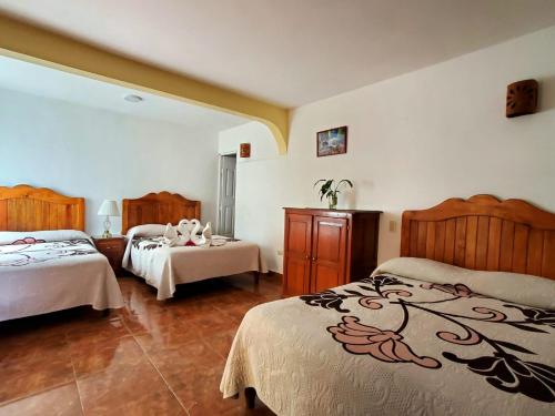a hotel room with two beds and a room with two at Hotel Posada Camelinas in Pátzcuaro