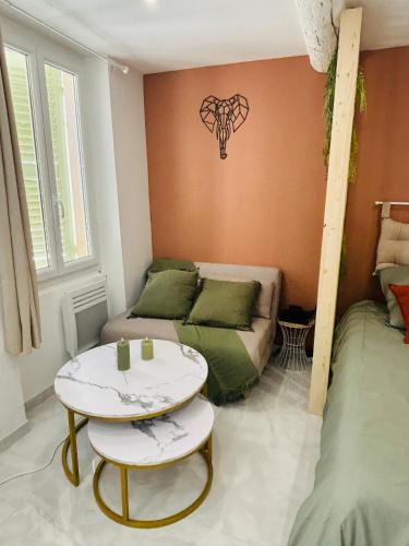 un salon avec un canapé et une table dans l'établissement Le Charvet, Studio cosy en plein cœur de Hyères, à Hyères