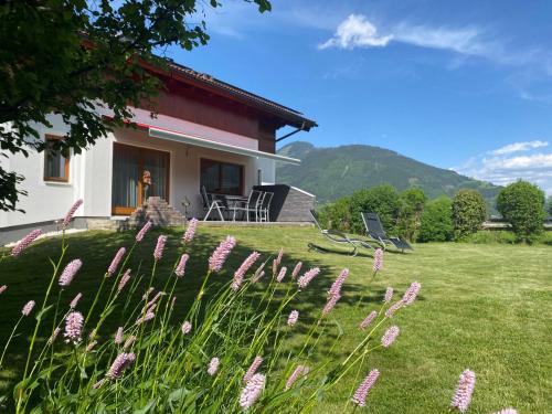 dom z fioletowymi kwiatami w ogrodzie w obiekcie Chalet Panoramablick Zell am See w mieście Zell am See