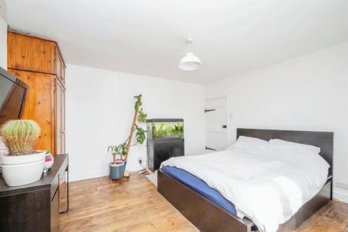 a bedroom with a bed and a tv in it at Lily Cottage In Idyllic Reedham in Reedham