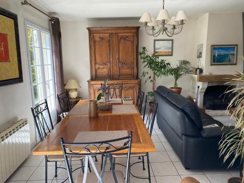 a living room with a table and a couch at Domaine de la coqueraine in Ouistreham