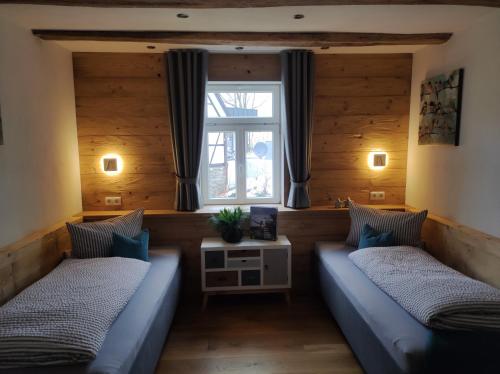 ein Wohnzimmer mit 2 Betten und einem Fenster in der Unterkunft Ferienwohnungen Schneider in Lennestadt