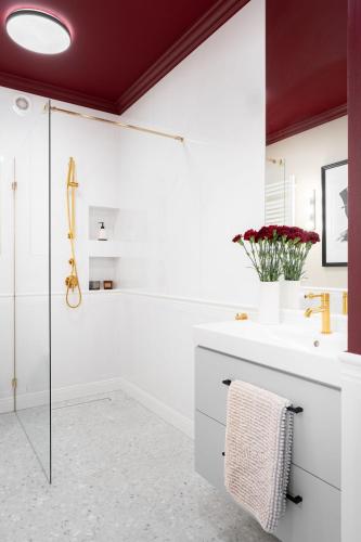 a white bathroom with a shower and a sink at Apartament Bajka in Grudziądz