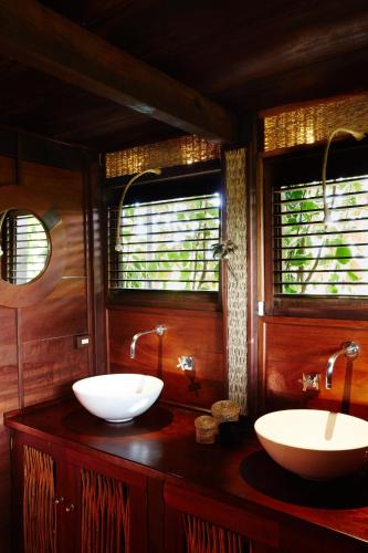 a bathroom with two sinks and two windows at La Ferme De Georges in Atins