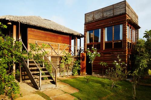 a wooden house with a staircase next to it at La Ferme De Georges in Atins