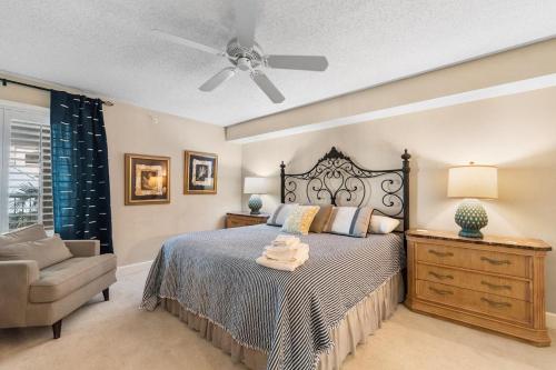 - une chambre avec un lit, une chaise et un ventilateur de plafond dans l'établissement Ocean Paradise: 4BR Condo in Litchfield By the Sea, à Pawleys Island