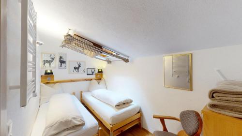 ein kleines Zimmer mit 2 Betten und einem Stuhl in der Unterkunft Alpine Style Kaprun in Kaprun