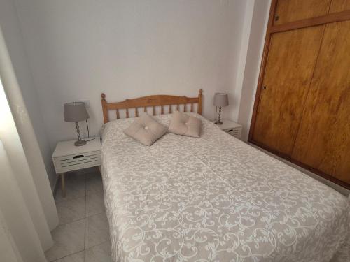 1 dormitorio con 1 cama con 2 mesitas de noche y 2 lámparas en Gladmar Apartment, en La Mata