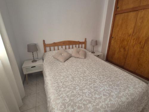 a bedroom with a bed with two night stands and two lamps at Gladmar Apartment in La Mata